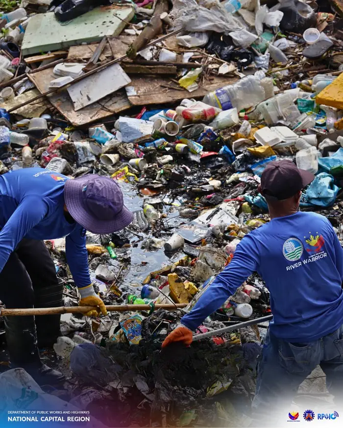 Workers clearing garbage from a waterway